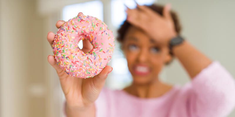 an upset woman holding a donut 
